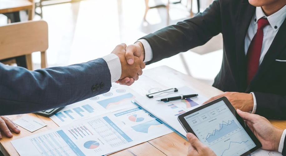 How We Handle Client Escalations at AMIS 2 A close-up handshake between business partners over growth analysis reports