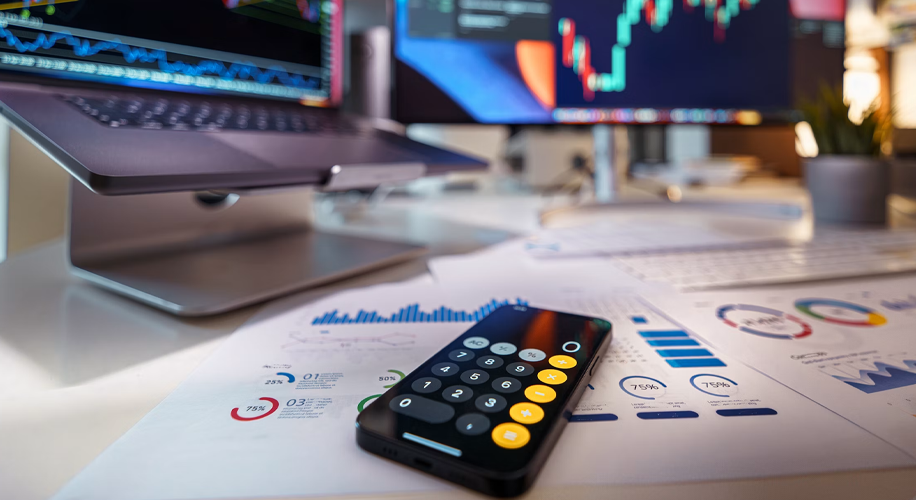 What Makes a Great Candidate in a Tech-Forward Accounting Firm 2 Financial analysis charts, a smartphone calculator, and trading monitors on a modern workspace